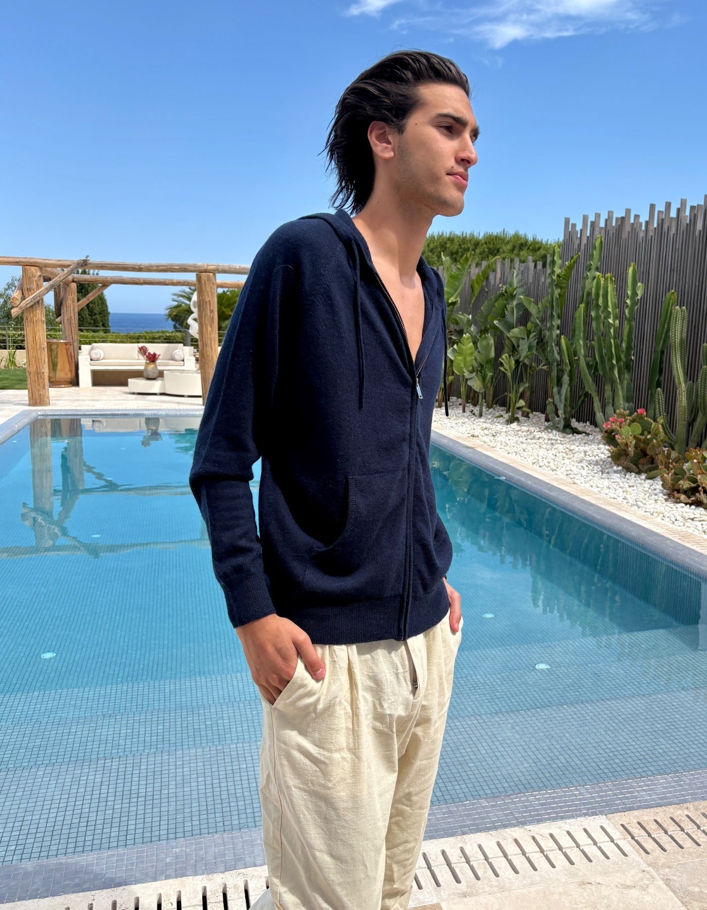 Man standing by a pool with a scenic background