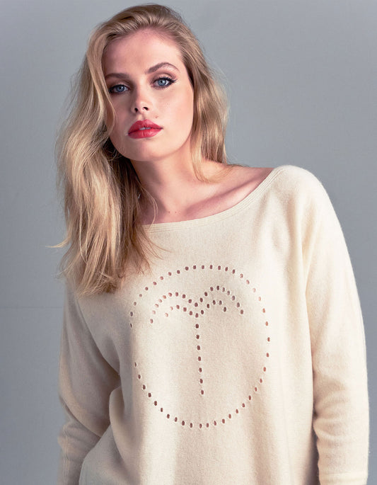 Studio photo of a model wearing a cashmere palm jumper in cream, part of the malin darlin designer cashmere collection.