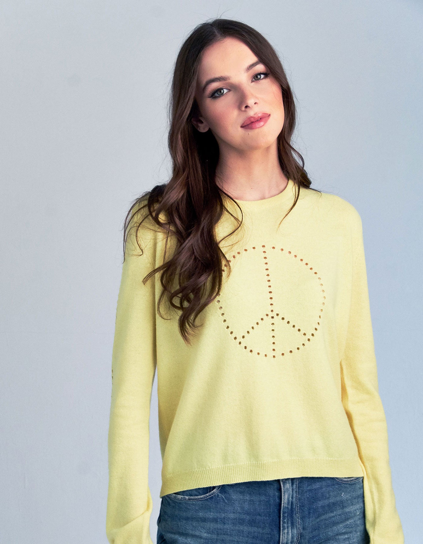 Studio photograph of a woman wearing a malin darlin Peace cashmere jumper.